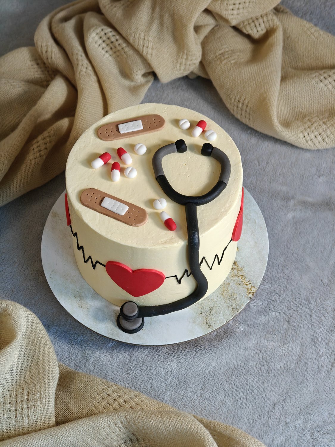 Doctor-themed cake with fondant stethoscope and heartbeat detail